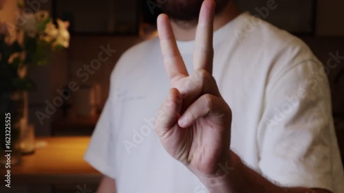 Man counting from one to five with one hand open palm to the camera