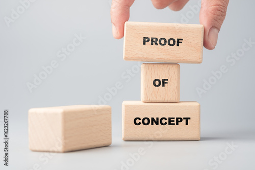 Photos Hand placing wooden blocks with the words proof of concept, symbolizing idea val
