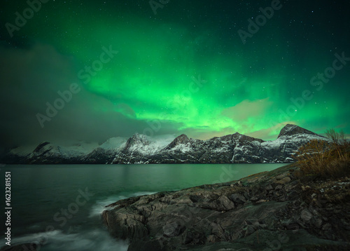 Northern lights over the snowy mountains of Senja, Norway