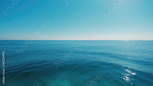 A vast ocean view with clear blue water under a bright sky.