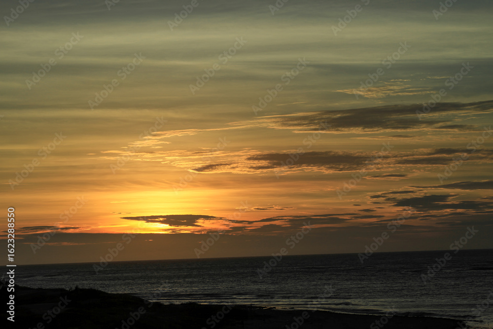 Fototapeta premium Golden sunset casting a warm glow over the seaside horizon at Longgang Miaoli Taiwan, captured in summer 2011 for a tranquil scene.