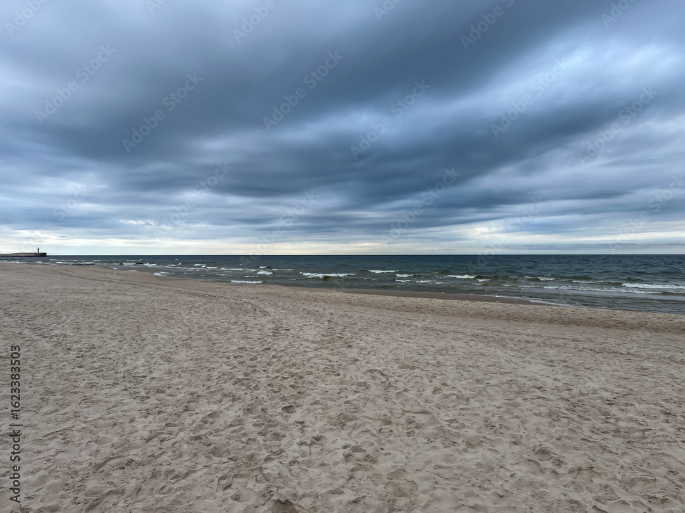 Fototapeta premium Empty Baltic beach in May with cloudy, calm weather, Mrzezyno region in Poland, as a background
