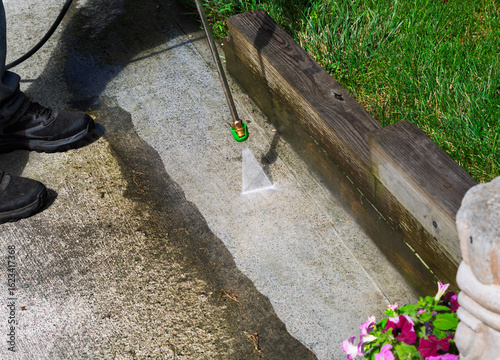 Cleaning a concrete patio with a pressure washing
hose