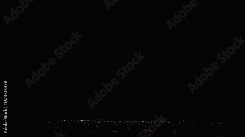 Night thunderstorm with striking lightning in dense clouds