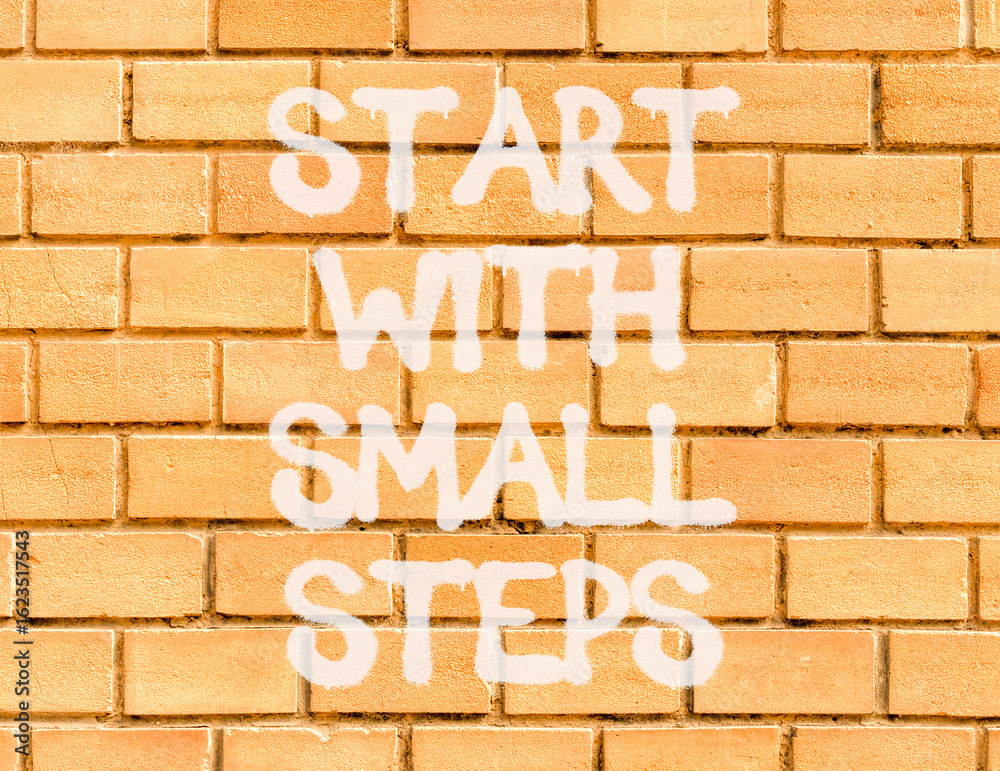 Start with small steps symbol. Concept words phrase Start with small steps on beautiful brown brick wall. Beautiful brown brick wall background. Business Start with small steps concept. Copy space. Start with small steps symbol. Concept words phrase Start with small steps on beautiful brown brick wall. Beautiful brown brick wall background. Business Start with small steps concept. Copy space.