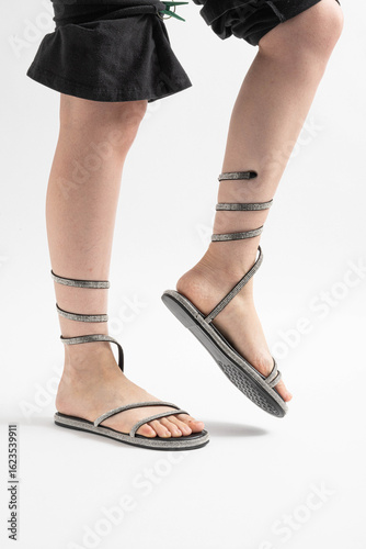 Sandalias brillantes con pedrería atadas al tobillo, ideales para el verano.