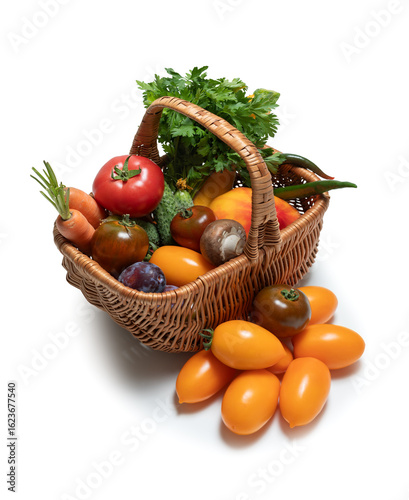 Basket with fresh vegetables and herbs on white background. Carrots, tomatoes, cucumbers, greens, mushrooms - everything for healthy diet. Isolated on white background