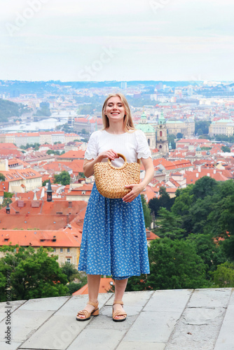 Photography Blonde woman poses in front of red rooftops in Prague, Czech Republic