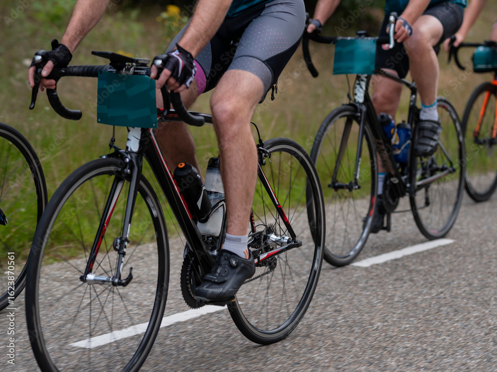 Naklejka premium Close-up of competitive cycling with aerodynamic time trial bikes and racing equipment during event