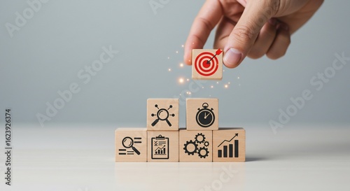 Hand Placing Target Block on Wooden Cubes Showing Business Strategy