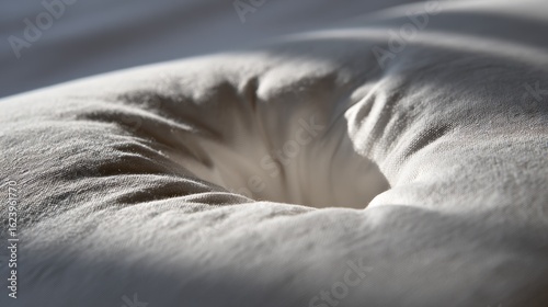 A slightly sunken indentation in a white linen pillow, lit to reveal a subtle thermal gradient fading from warm to cool.