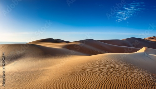 metallic sand dunes shifting under a bright blue sky displaying liquid chrome texture