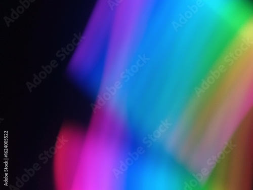 A multicolored abstract by moving strokes of light, creating bright, swirling streaks of rainbow-colored light on a dark background