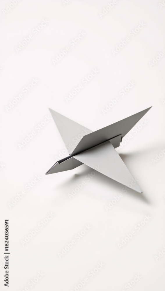 Fototapeta premium A single-sheet origami white paper airplane isolated on a pristine white background