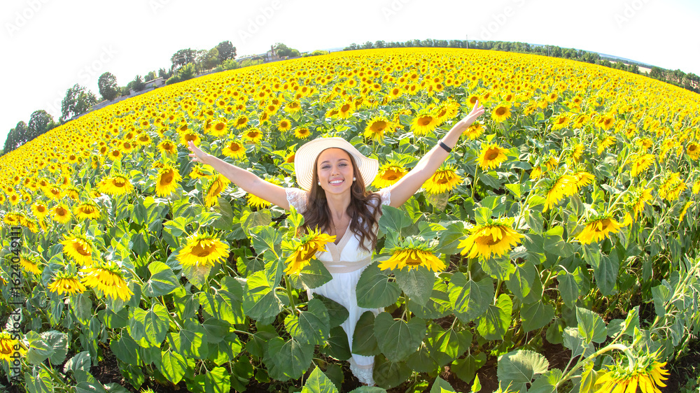 Fototapeta premium Woman enjoying sunny day in vibrant sunflower field during summer