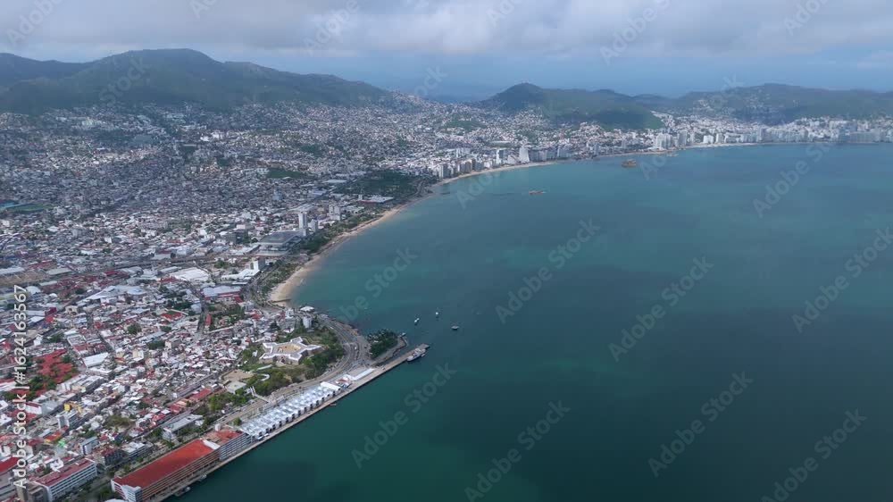 Breathtaking aerial tour of Acapulco Bay: an epic drone video capturing the stunning cityscape, mountainous backdrop, and the vibrant coastline of this world-famous Mexican paradise. Breathtaking aerial tour of Acapulco Bay: an epic drone video capturing the stunning cityscape, mountainous backdrop, and the vibrant coastline of this world-famous Mexican paradise.