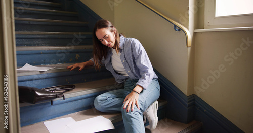 Fotografie Injured Woman Sitting On Staircase After Slip And Fall Accident