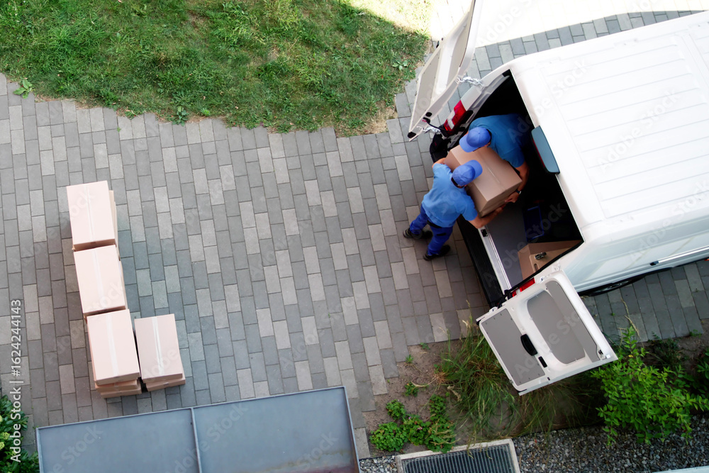 Fototapeta premium Busy Movers Unloading Furniture From Delivery Truck