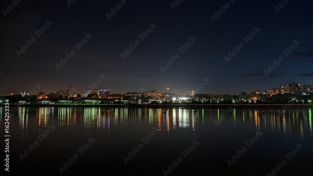 Obraz premium Bright Moon above the night city and river