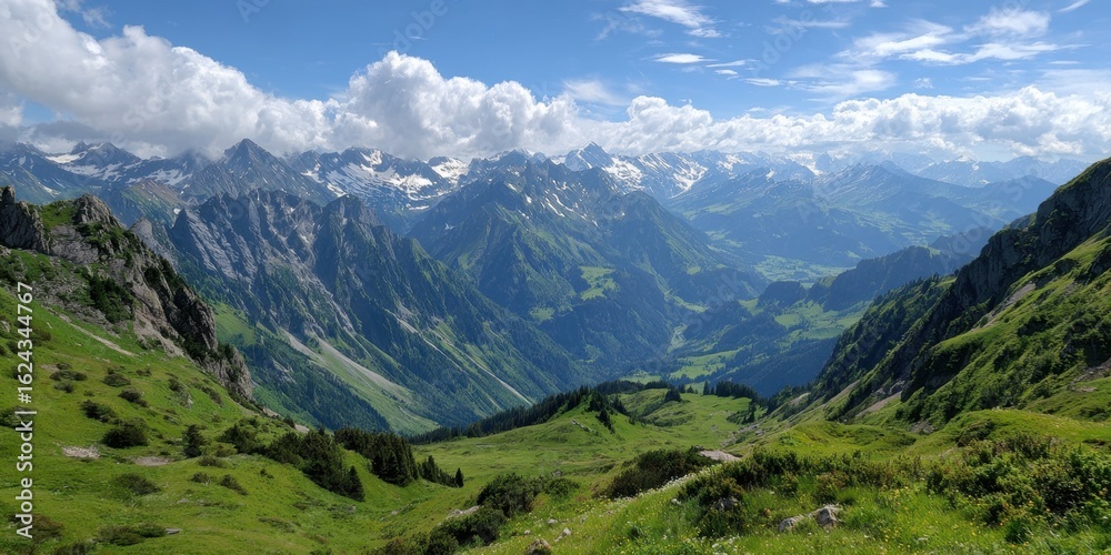 Fototapeta premium A breathtaking vista unfolds across a verdant mountain valley, with majestic peaks rising towards a sky adorned with fluffy white clouds, creating a serene and awe-inspiring natural landscape.