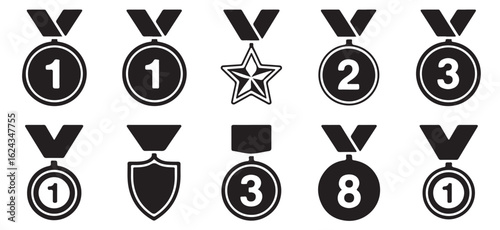 Collection of black and white award medals and badges with various designs and ribbon attachments