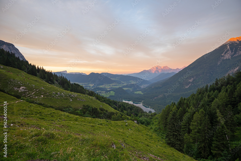 Fototapeta premium Magischer Sonnenuntergang an der Halsalm über dem Hintersee mit Blick zum Hoher Göll, Hochkalter und Untersberg.