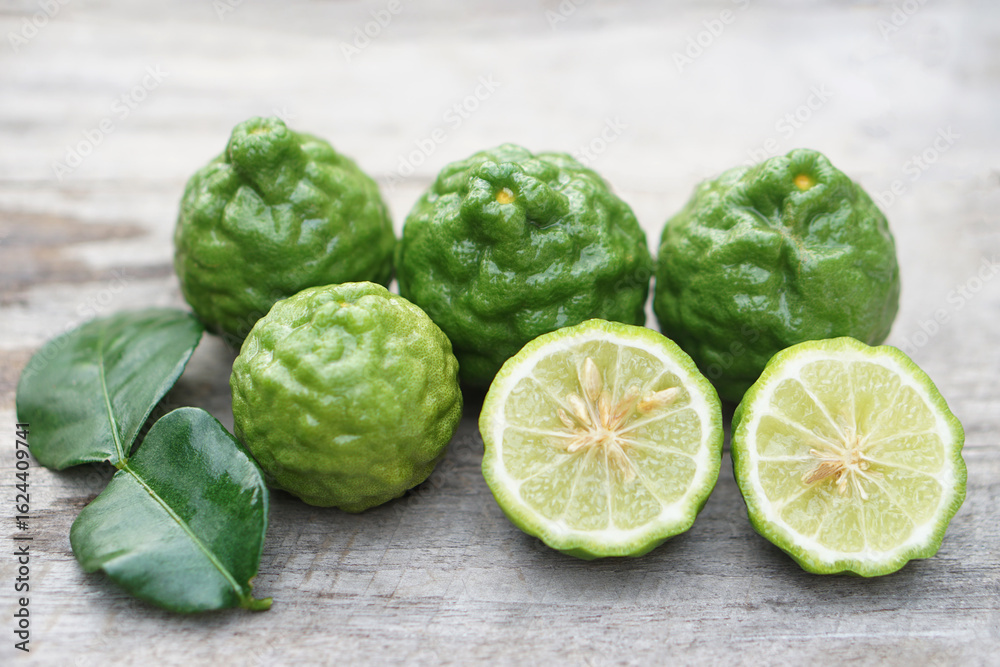 Fototapeta premium Fresh kaffir limes fruits. Aromatic Thai herb is used for cooking with sour taste, natural shampoo and homemade cleaners. Known for its citrusy fragrance and traditional medicinal properties. 