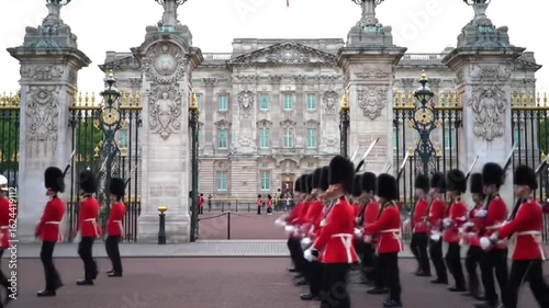 The traditional Changing of the Guard ceremony with royal soldiers in red uniforms marching in formation outside the iconic palace in London.