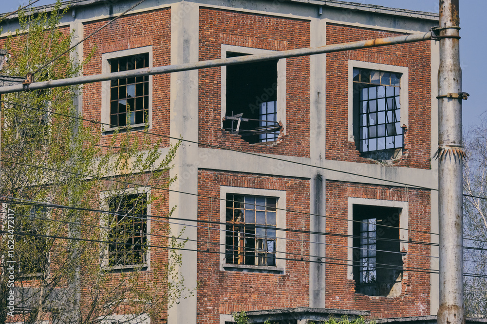 Fototapeta premium Abandoned Industrial Chimney Tower with Overgrown Vegetation