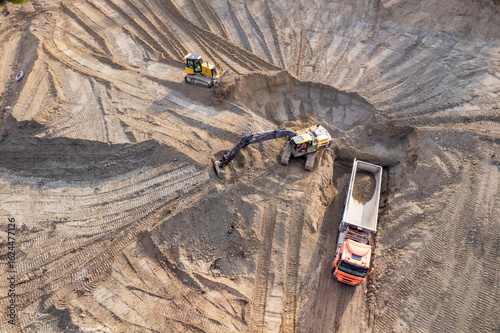 aerial view of quarry. excavator loading sand into dump truck