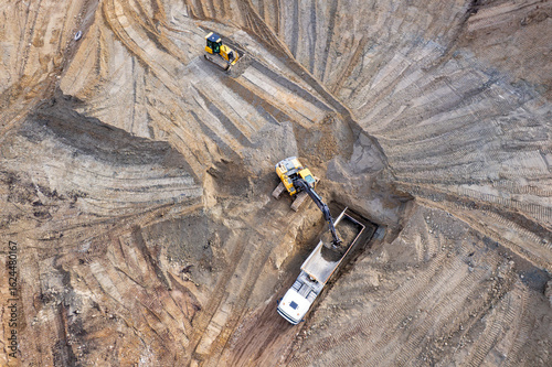 aerial view of quarry. excavator loading sand into dump truck