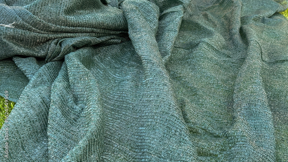 Fototapeta premium Draped in verdant knitted whispers, the fabric tells tales of Hygge warmth and World Textile Day marvels