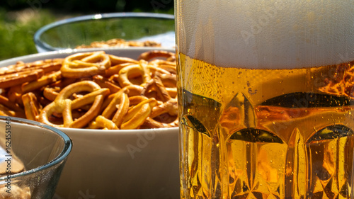 Fotografie Frothy golden lager beside crispy pretzel twists, Oktoberfest revelry, barley ha