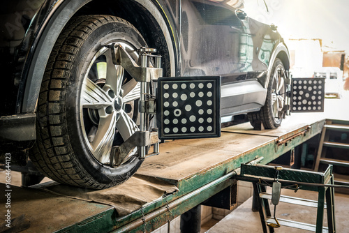 Car wheel alignment. Auto camber toe check fixing. Sensor during suspension adjustment and automobile wheel alignment work at the repair service station