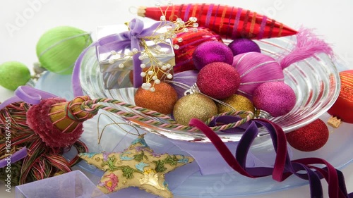 Bright colourful sparkling baubles and gift on a plate