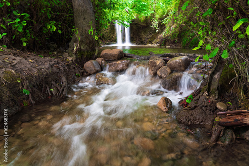 Small magnificent waterfall in a green forest