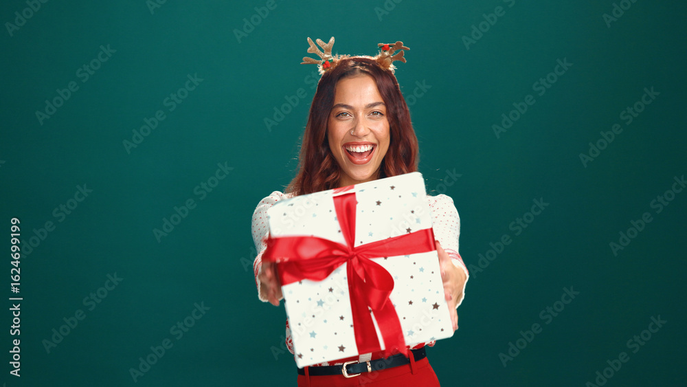 Christmas, portrait and happy woman offer gift in studio, holiday surprise and celebration. Smile, person and giving present for xmas, festive giveaway and laugh on green background with mockup space Christmas, portrait and happy woman offer gift in studio, holiday surprise and celebration. Smile, person and giving present for xmas, festive giveaway and laugh on green background with mockup space