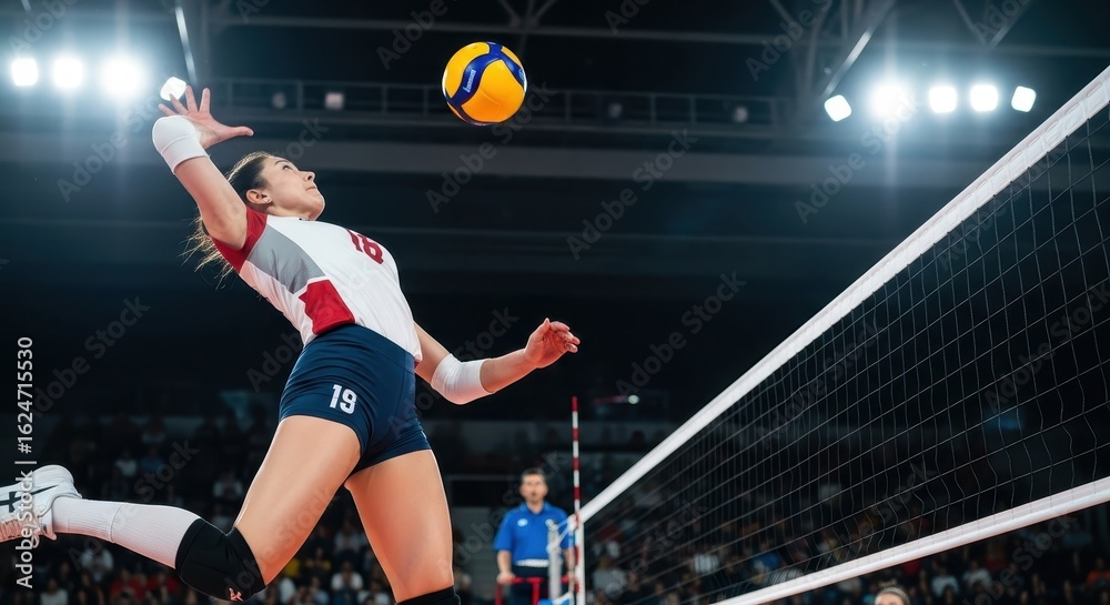 © Chainarong - A powerful female volleyball player in mid-air, spiking the ball hard over the net in a stadium. © Chainarong - A powerful female volleyball player in mid-air, spiking the ball hard over the net in a stadium.