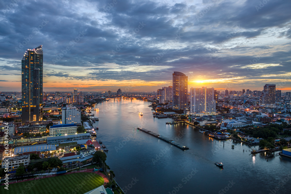 Fototapeta premium Modern buildings in the city with water reflection, firework, light show, river ferry boat at twilight time.
