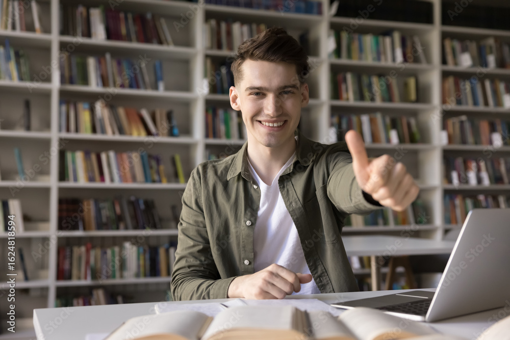 © fizkes - Study success in blended learning. Portrait smiling male zoomer high school student sitting at classroom desk use notebook open books show thumbs up to camera completing task enjoying productive work © fizkes - Study success in blended learning. Portrait smiling male zoomer high school student sitting at classroom desk use notebook open books show thumbs up to camera completing task enjoying productive work