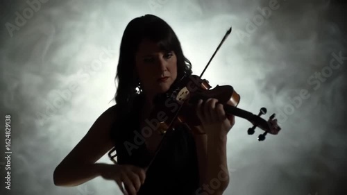 Woman playing violin in smoky