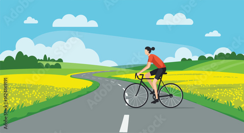 Woman cycling outdoors on a country road with rapeseed fields & cloudy blue sky