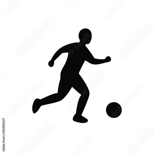 Silhouette of a soccer player kicking ball