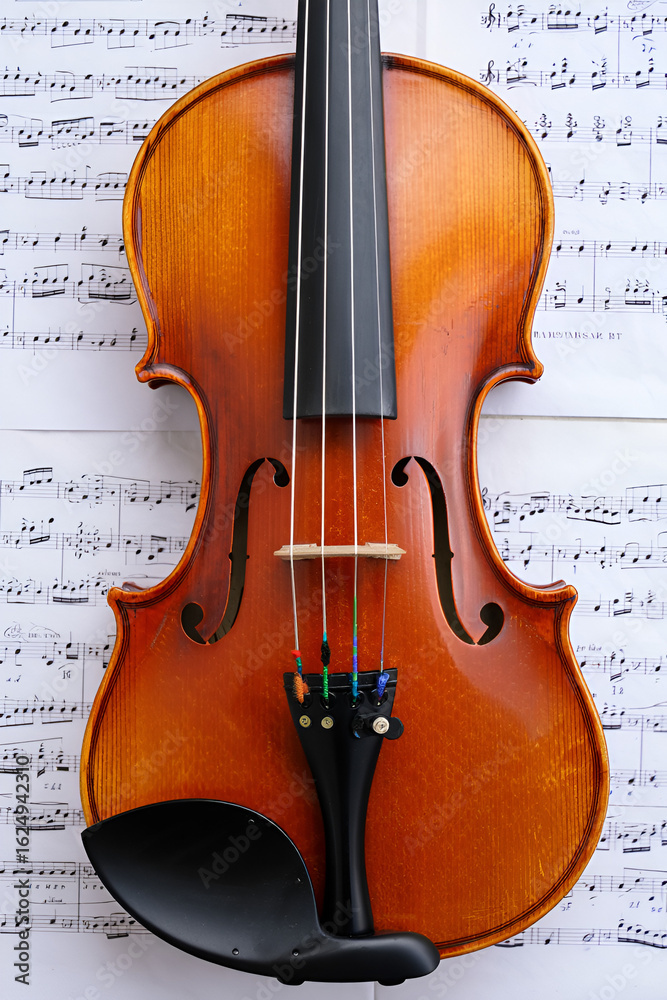 Fototapeta premium Violin on sheet music. Close up. Top view.