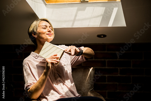 Photography Woman enjoying a moment of tranquility while reading a book in cozy indoor space