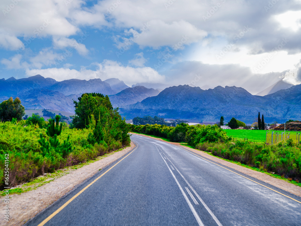 Naklejka premium Winding road through rural Villiersdorp village with Riviersonderend Mountains backdrop, South Africa
