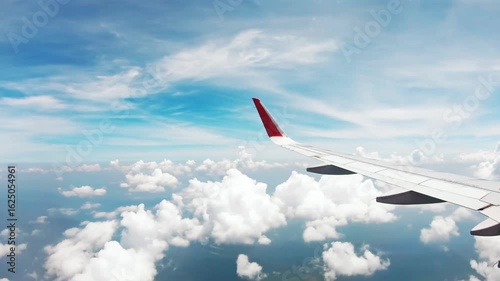 Airplane wing in the sky with clouds, a journey to a vacation destination