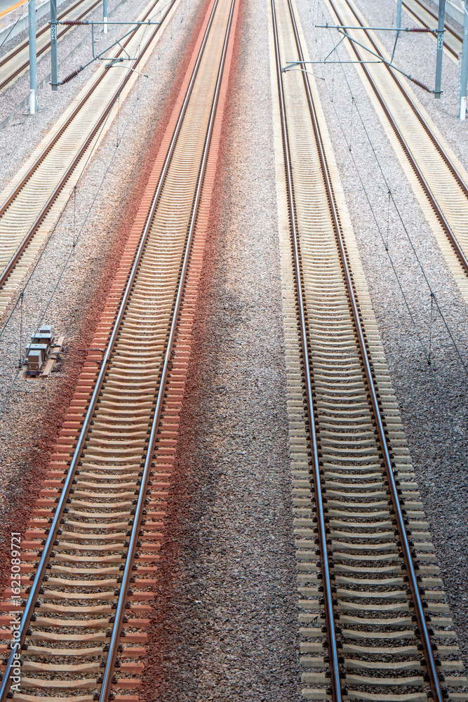 Obraz premium An aerial view of multiple railway tracks stretching into the distance, symbolizing transportation, journey, and the efficiency of modern railway systems.