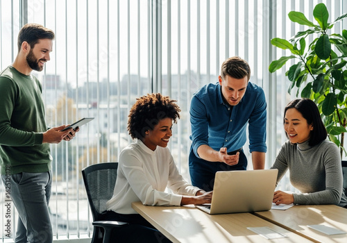 Diverse business team collaborating around a laptop in a modern office