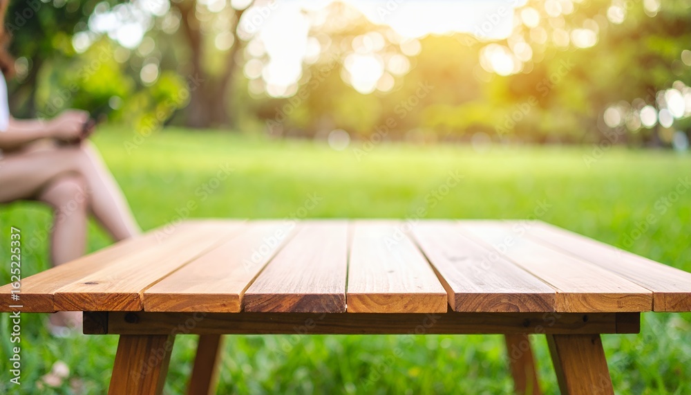 Fototapeta premium Empty wooden table for product display in a sunny park background